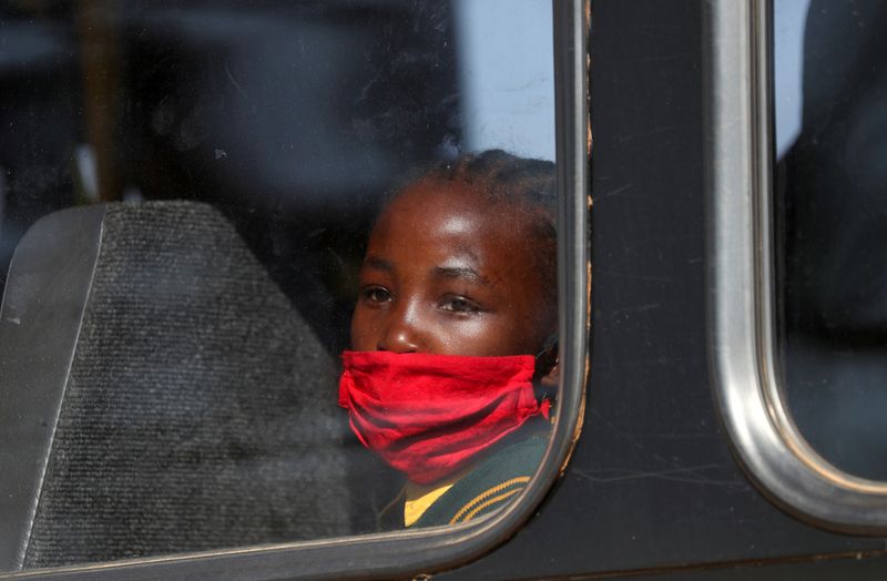 &copy; Reuters. Menina de máscara dentro de ônibus em Johanesburgo