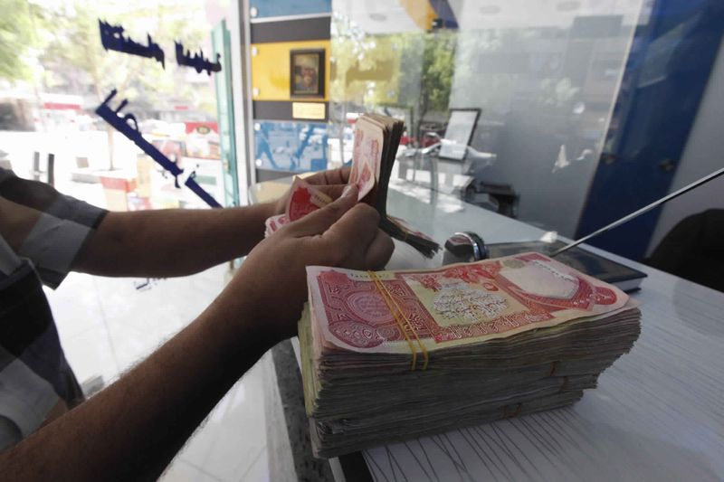 &copy; Reuters. البنك المركزي العراقي يخفض قيمة الدينار أمام الدولار