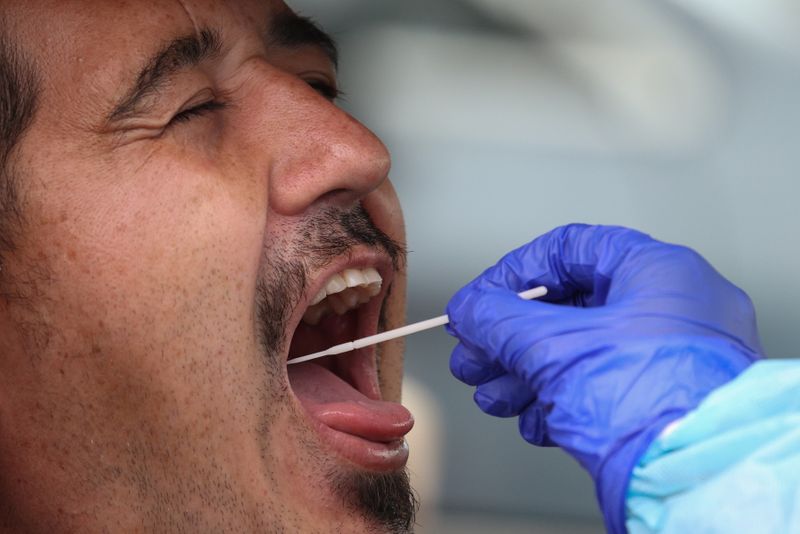 &copy; Reuters. A person is swabbed by a medical professional at a drive-through coronavirus disease testing clinic in Sydney