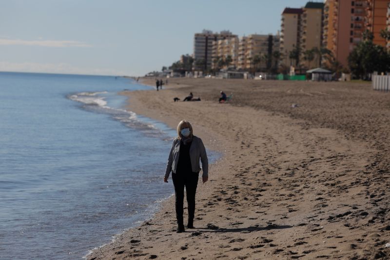 © Reuters. British resident Michelle Jones walks as she poses for a photo in front of the Mediterranean Sea on a beach in Fuengirola