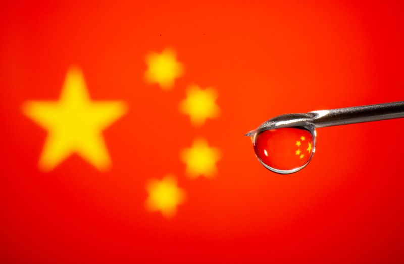 &copy; Reuters. Gota cai de agulha de seringa em frente a bandeira da China em foto de ilustração