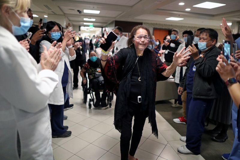 &copy; Reuters. Intensive Care Unit Nurse Merlin Pambuan, is cheered by hospital staff as she walks out of the hospital in Long Beach