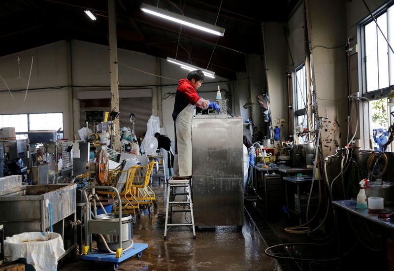 © Reuters. A worker cleans a second-hand kitchen item at Tenpos Busters's reuse center in Yokohama