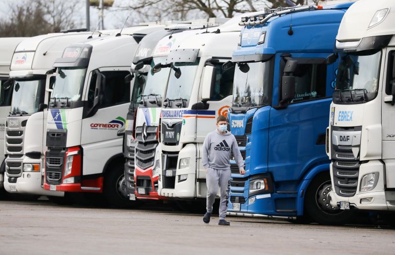 &copy; Reuters. A driver walks past lorries at Ashford International Truck Stop