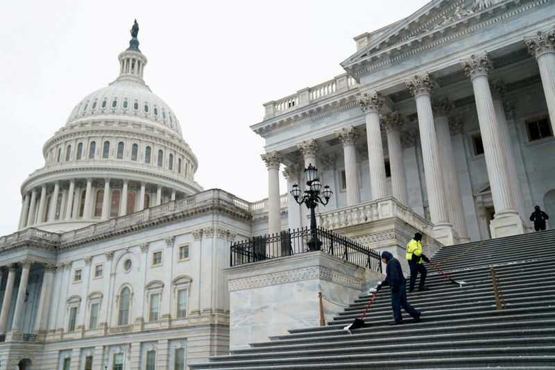 &copy; Reuters. FILE PHOTO: Workers shovel snow from the steps of the U.S. Capitol in Washington
