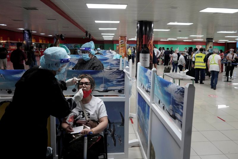 © Reuters. Profissional da saúde faz teste de Covid-19 em turista no aeroporto de Havana, Cuba