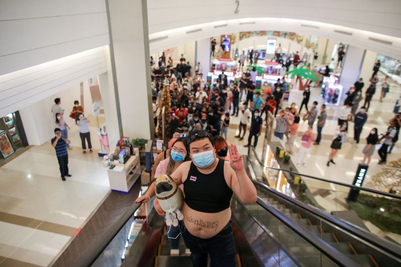 &copy; Reuters. FILE PHOTO:Protest leaders Panusaya &quot;Rung&quot; Sithijirawattanakul and Parit &quot;Penguin&quot; Chiwarak wearing crop tops ride on an escalator at Siam Paragon shopping centre, as they demonstrate against the monarchy, in Bangkok