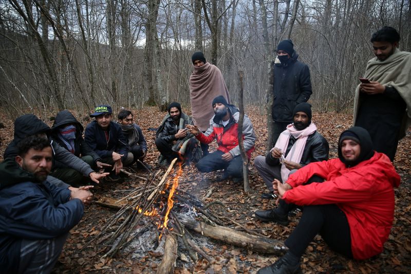 &copy; Reuters. Migrants try to warm themselves near the burned migrant center &quot;Lipa&quot; in Bihac