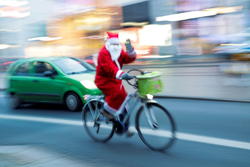 © Reuters. FILE PHOTO: 'Santa Claus' rides a bike on city street