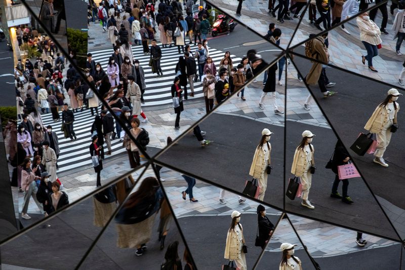 &copy; Reuters. People wearing protective masks, following an outbreak of the coronavirus disease (COVID-19), are reflected in the mirror at a shopping mall in Tokyo