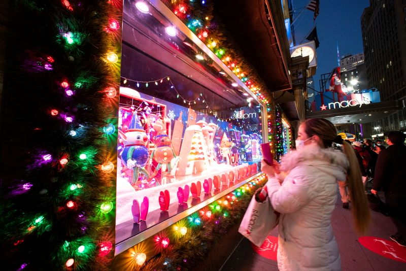 © Reuters. FILE PHOTO: A woman takes pictures of Christmas window at the Macy's Herald Square store in New York City