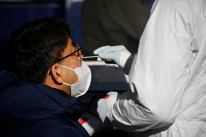 &copy; Reuters. FILE PHOTO:  A man undergoes coronavirus disease (COVID-19) test at a coronavirus testing site in Seoul