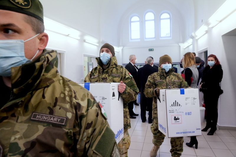 &copy; Reuters. Hungarian soldiers carry the first shipment of Pfizer-BioNTech coronavirus disease (COVID-19) vaccines at the Del-Pest Central Hospital in Budapest