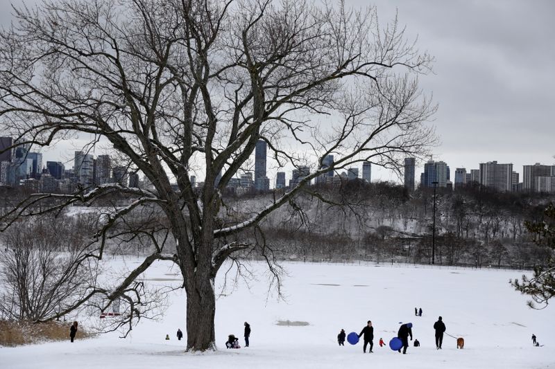 &copy; Reuters. Families enjoy tobogganing during the fresh Christmas snowfall at Riverdale Park East in Toronto