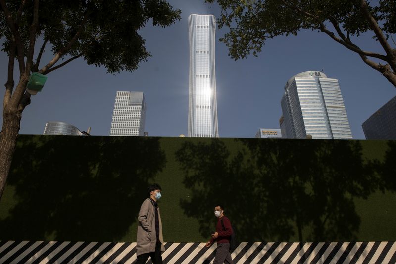 &copy; Reuters. People walk past the skyline of the Central Business District (CBD) on the day that Chinese leaders elaborate on their 14th Five-Year plan in Beijing