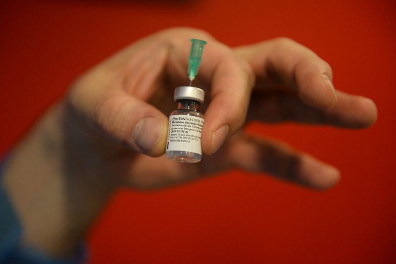 &copy; Reuters. Profissional de saúde segura frasco de vacina contra Covid-19 Pfizer/BioNTech em Bruxelas