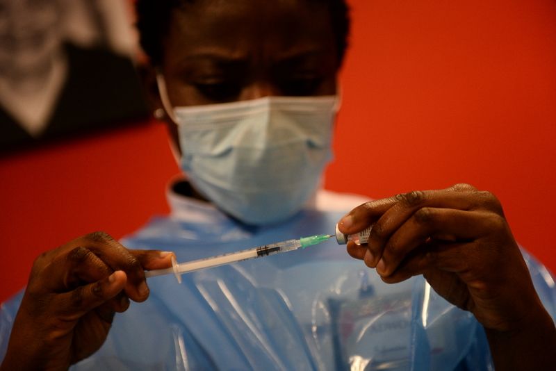&copy; Reuters. Un operatore sanitario tiene in mano una siringa col vaccino Pfizer/BioNtech contro il COVID-19