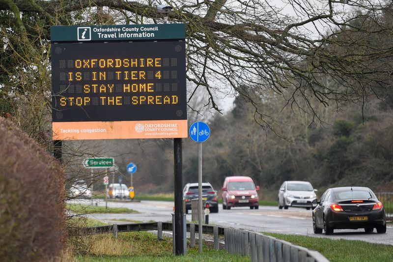 &copy; Reuters. Vehicles drive past a roadside public health information sign, amidst the spread of the coronavirus disease (COVID-19) pandemic, near Oxford