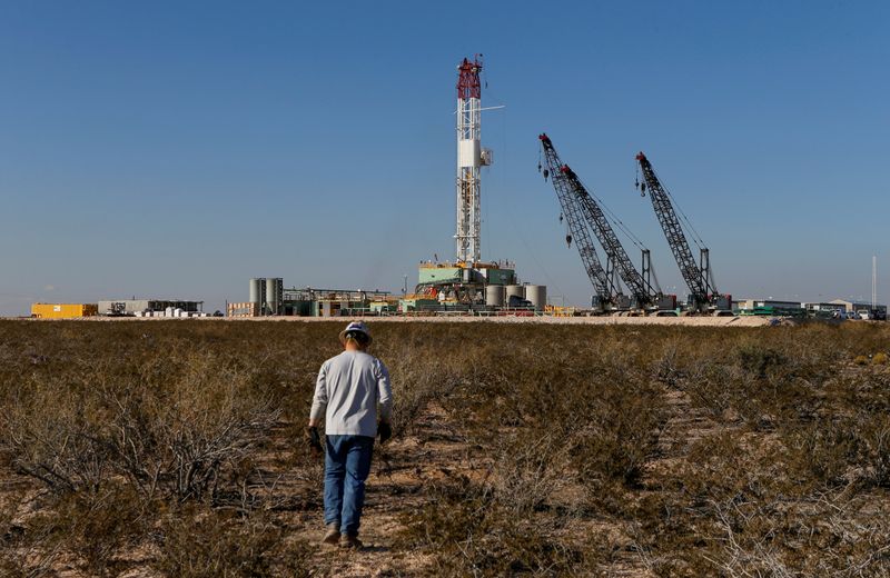 © Reuters.  FOTO DE ARCHIVO: Un trabajador petrolero camina hacia una plataforma de perforación en el condado de Loving, Texas