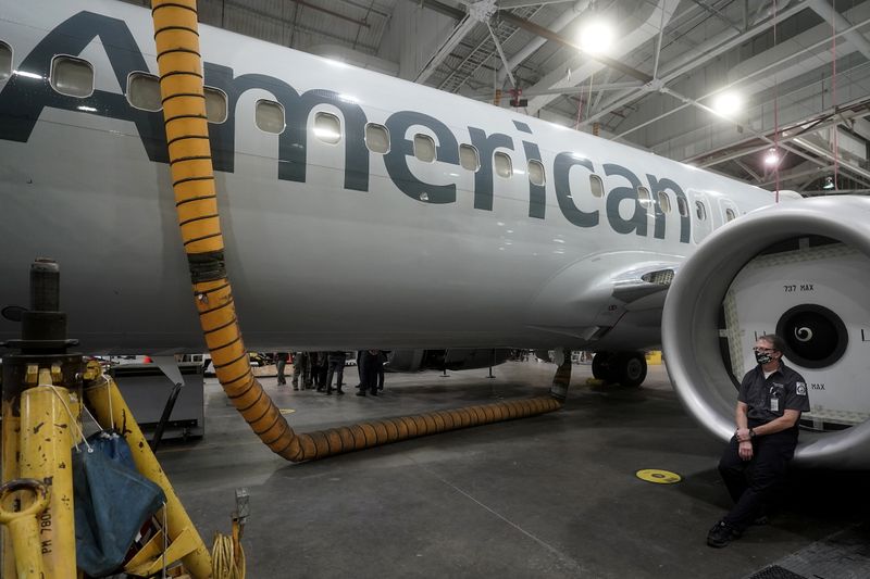 © Reuters. An American Airlines worker sits on an engine cowl of a Boeing 737 Max airplane in a maintenance hanger in Tulsa