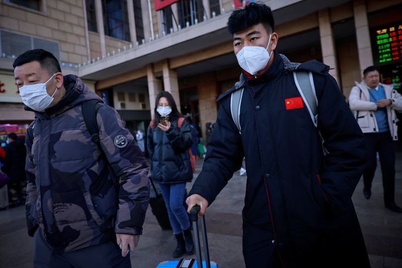 &copy; Reuters. Pessoas carregam malas ao deixarem estação ferroviária em Pequim em meio à pandemia de Covid-19