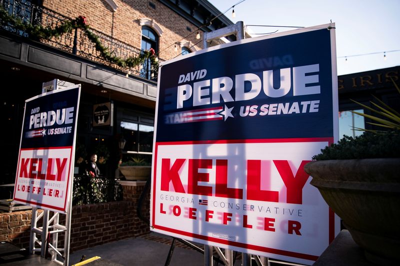 &copy; Reuters. Cartazes das campanhas a uma cadeira pela Geórgia no Senado dos EUA dos candidatos republicanos David Perdue e Kelly Loeffer