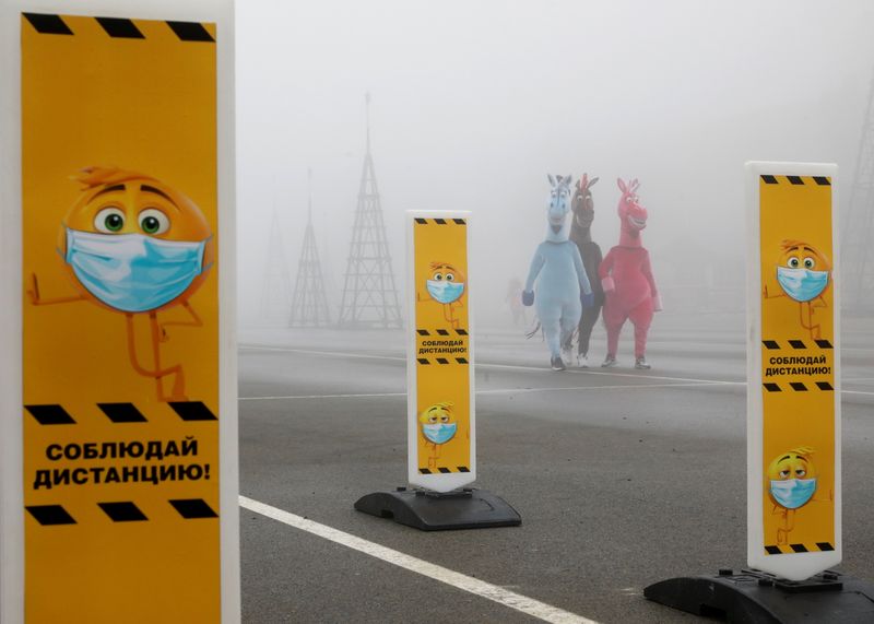 &copy; Reuters. Pedestrians walk past social distancing signs placed near a skating rink amid the coronavirus disease outbreak in Stavropol
