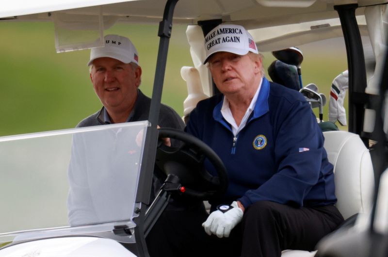 &copy; Reuters. FILE PHOTO: U.S. President Donald Trump drives a golf cart at the Trump National Golf Club in Sterling