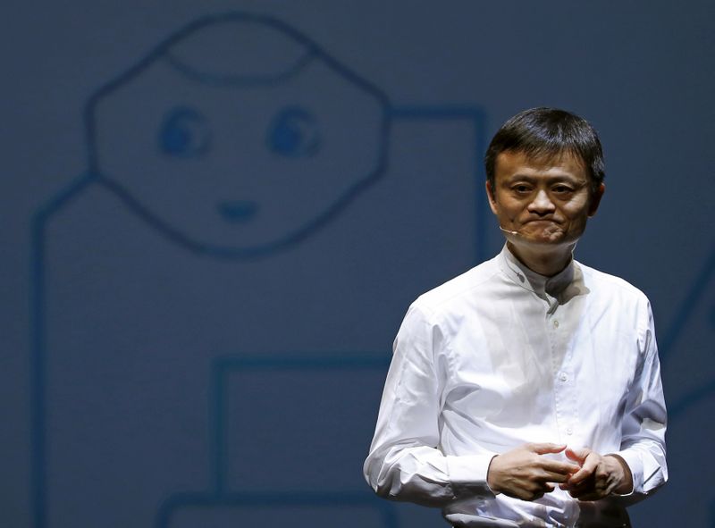 © Reuters. FILE PHOTO - Jack Ma, founder and executive chairman of China's Alibaba Group, speaks in front of a picture of SoftBank's human-like robot named 'pepper' during a news conference in Chiba