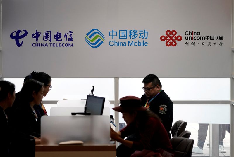 © Reuters. FILE PHOTO: Signs of China Telecom, China Mobile and China Unicom are seen during the China International Import Expo at the National Exhibition and Convention Center in Shanghai