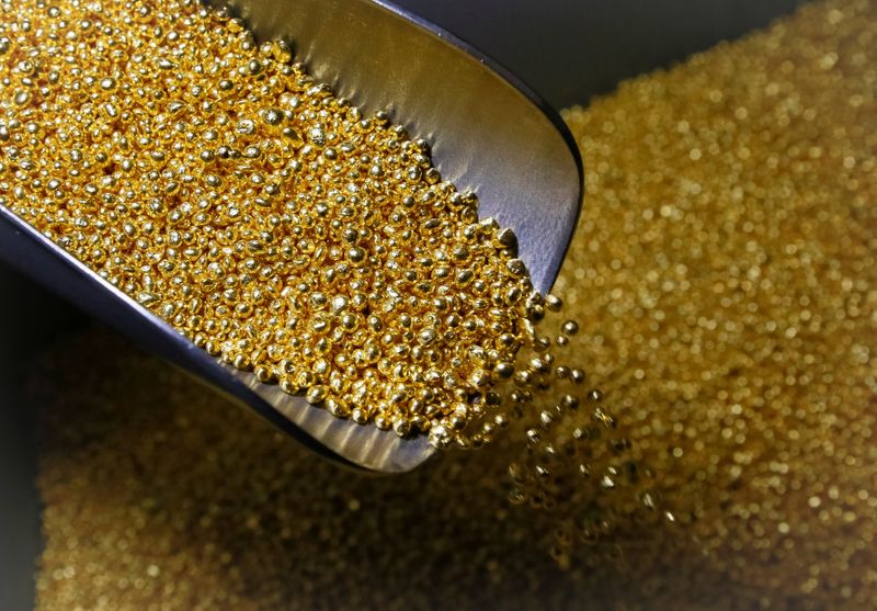 © Reuters. An employee takes granules of 99.99 percent pure gold at the Krastsvetmet non-ferrous metals plant in the Siberian city of Krasnoyarsk