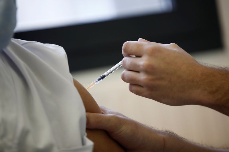 &copy; Reuters. Profissional de saúde aplica vacina Pfizer/BioNTech contra Covid-19 em paciente em hospital em Nanterre, na França