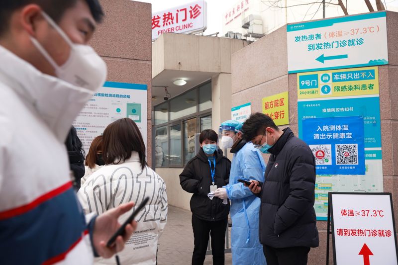 &copy; Reuters. Medical staff advice people outside a nucleic testing site at a hospital in Beijing