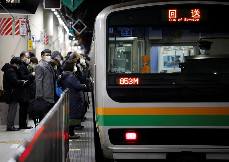 &copy; Reuters. Commuters wearing protective face masks wait to enter a train on the way home, amid the coronavirus disease (COVID-19) outbreak in Tokyo