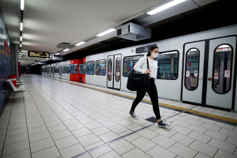 &copy; Reuters. FILE PHOTO: A commuter wearing a face mask walks at the Cologne main station in Cologne