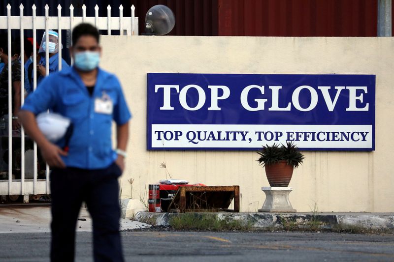 © Reuters. FILE PHOTO: A worker leaves a Top Glove factory after his shift in Klang