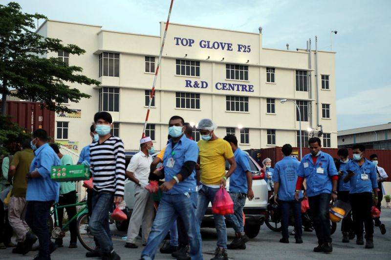 &copy; Reuters. FILE PHOTO: Workers leave a Top Glove factory after their shifts in Klang