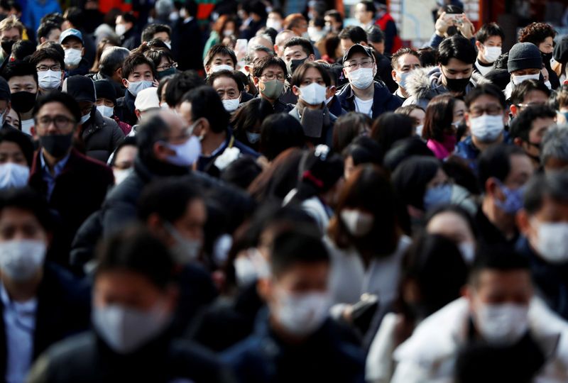 &copy; Reuters. Decenas de personas con mascarillas espera para presentar sus oraciones en el primer día laborable del año en el santuario de Kanda Myojin en Tokio, Japón.