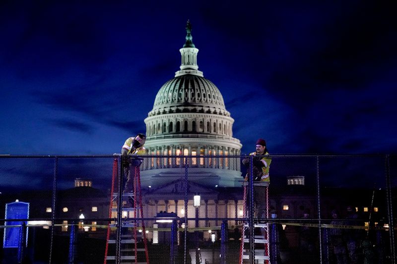 &copy; Reuters. FILE PHOTO: Workers install heavy-duty security fencing around the U.S. Capitol a day after supporters of U.S. President Donald Trump stormed the Capito