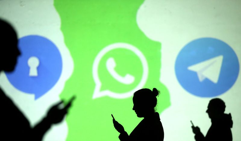 &copy; Reuters. Silhouettes of mobile users are seen next to logos of social media apps Signal, Whatsapp and Telegram projected on a screen in this picture illustration