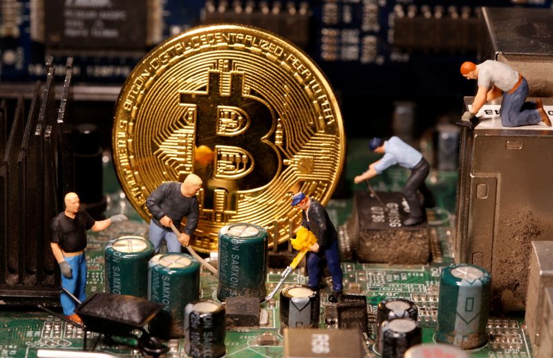 © Reuters. A representation of virtual currency Bitcoin and small toy figures are placed on computer motherboard