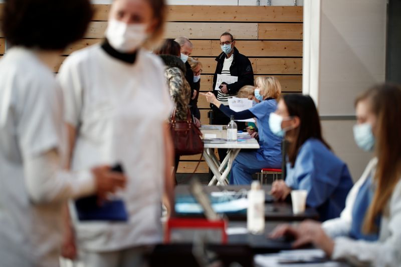 &copy; Reuters. Trabajadores de la salud esperan para recibir la vacuna COVID-19 de Pfizer-BioNTech en un centro de vacunación dentro de un gimnasio en Taverny cerca de París, Francia, el 9 de enero de 2021