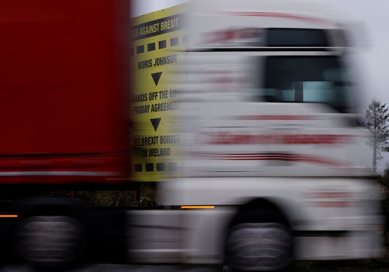 &copy; Reuters. A lorry passes a Brexit themed poster on the road close to the border between Northern Ireland and Ireland near Newry