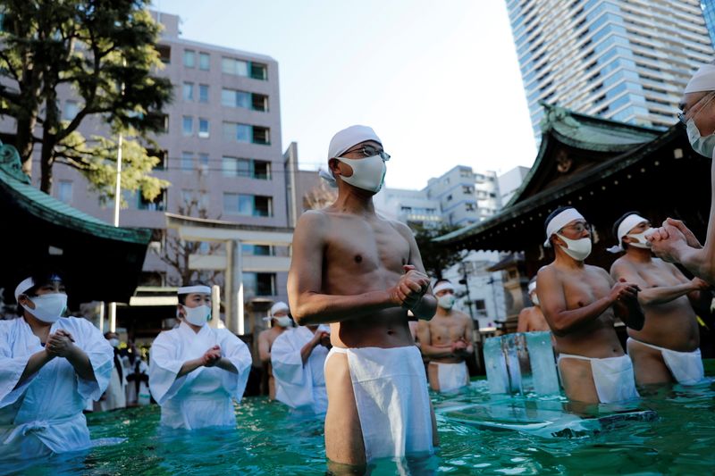&copy; Reuters. Participants wearing protective face masks amid the coronavirus disease (COVID-19) outbreak, take an ice-cold bath at a ceremony in Tokyo