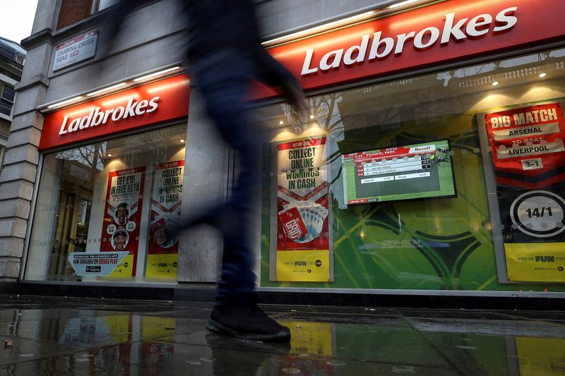 © Reuters. FILE PHOTO: A pedestrian walks past a branch of Ladbrokes in London