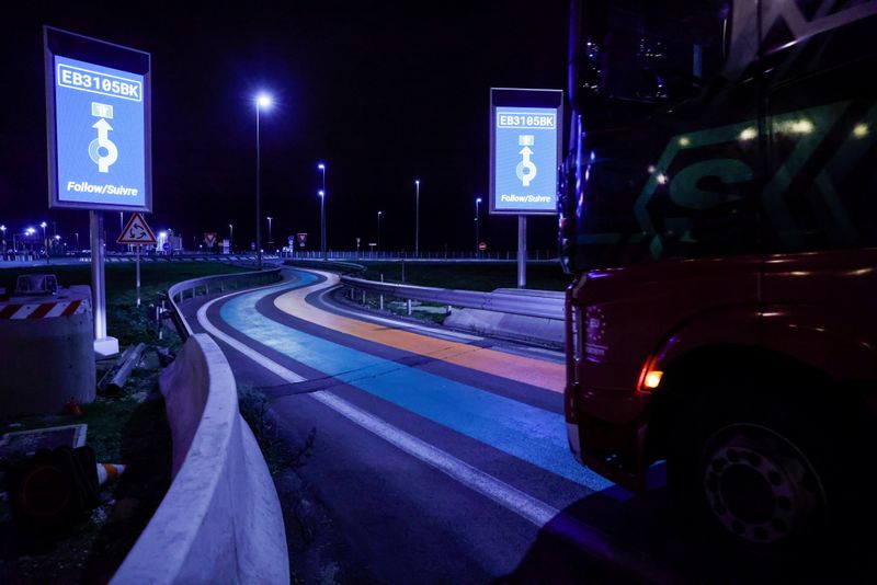 &copy; Reuters. Un camión pasa por encima de las líneas verdes y naranjas de la carretera que forman parte de la nueva infraestructura aduanera para la entrada en Francia, en Calais, Francia, el 1 de enero de 2021