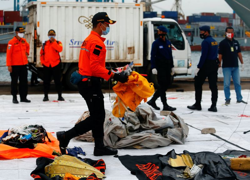 &copy; Reuters. Un miembro del personal de rescate indonesio transporta los presuntos restos del vuelo SJ 182 de Sriwijaya Air que se estrelló en el mar frente a la costa de Yakarta, en el puerto de la Terminal Internacional de Contenedores de Yakarta (Indonesia), el 11