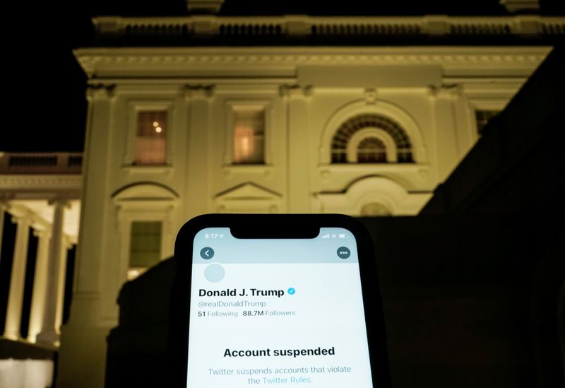 © Reuters. A photo illustration shows the suspended Twitter account of U.S. President Donald Trump on a smartphone and the White House in Washington