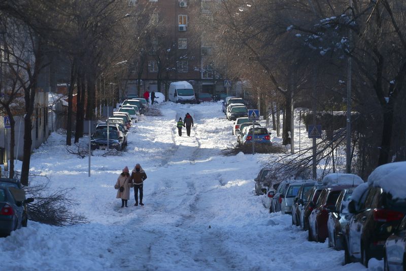 &copy; Reuters. Gente por una calle cubierta de nieve después de una fuerte nevada en Madrid, España, el 11 de enero de 2021