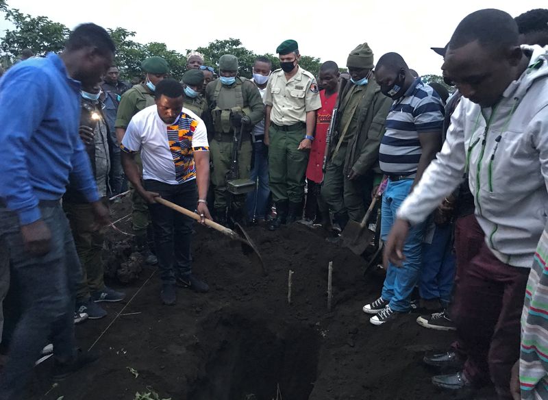 © Reuters. Virunga National Park Rangers watch as civilians bury the body of Congolese ranger Burhani Abdou Surumwe who was killed in an ambush in Virunga National Park, a sanctuary for endangered mountain gorillas, in Goma